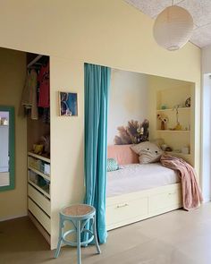 a bed room with a neatly made bed and blue curtains