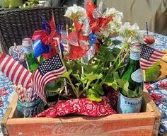 a wooden box filled with flowers and bottles on top of a blue cloth covered table