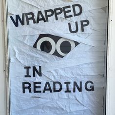 a sign that says wrapped up in reading on the front door with an eye drawn on it