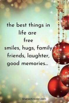 three red ornaments hanging from strings with the words, the best things in life are free smiles, hugs, family friends, laughter, good memories