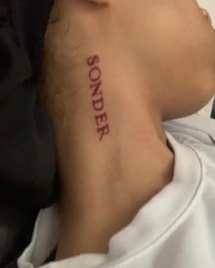 the back of a man's neck with a tattoo that reads, sonder