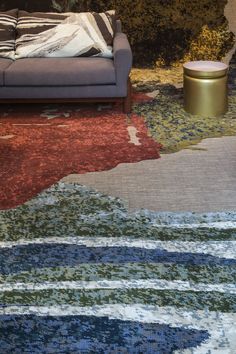 a living room with a couch and rugs on the floor in front of it