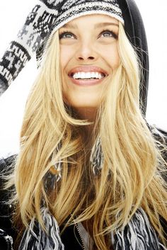 a woman with long blonde hair wearing a black and white knitted beanie hat