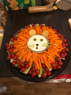 a lion made out of carrots and crackers on top of a black plate