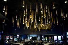 a casino room filled with lots of slot machines and chandeliers hanging from the ceiling