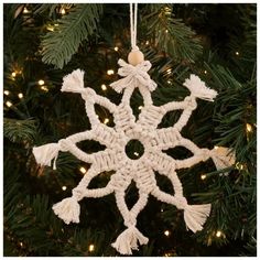 a crocheted snowflake ornament hanging from a christmas tree