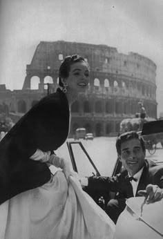 a woman sitting in the driver's seat of a car next to a man