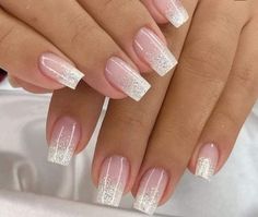 two hands with white and pink manies on their nails, one is holding the other's hand