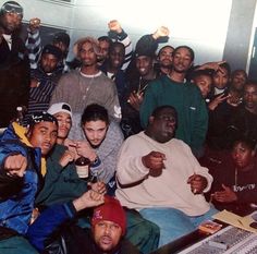 a group of young men sitting next to each other in front of a mixing desk