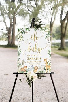 a baby shower sign with greenery and flowers