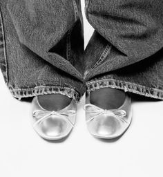 black and white photograph of someone's feet wearing silver shoes