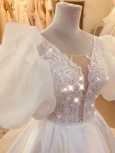 a white wedding dress on display at a bridal gown shop in the evening hours