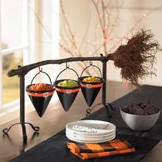 a table topped with plates and bowls filled with food next to a tree branch decorated with lights