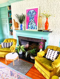 a living room filled with furniture and a fire place covered in paintings on the wall