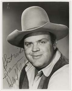 a black and white photo of a man wearing a cowboy hat