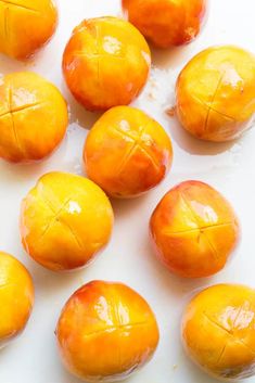 several peeled oranges on a white surface