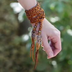 This versatile piece can be worn as a wrap bracelet, a lariat necklace, a choker, a headband, an armband, an ankle bracelet, a hat accessory, or even a belt. Get creative! The braided deerskin leather is finished with handmade brass beads and pheasant feathers. One size. African Brass Beads, Leather Creations, Black Statement Earrings, Tassel Earing, Braid Jewelry, South Pasadena, Try On Hairstyles, Handmade Stuff, Pheasant Feathers