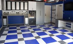 a kitchen with blue and white checkered flooring, cabinets and appliances in it