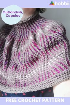 a woman wearing a knitted hat with pink and silver designs on it's side