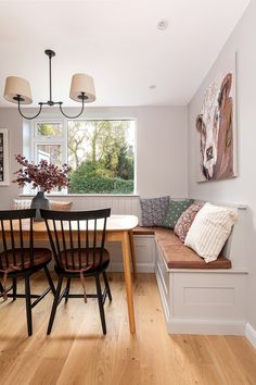 a dining room table with two chairs and a bench