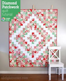 a white chair sitting in front of a wall with a red and green quilt on it