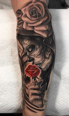 a person with a rose and skull tattoo on their leg is shown in black and grey