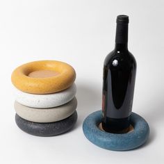 a bottle of wine sitting next to three stone coasters