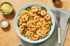 a bowl of pasta with shrimp and zucchini