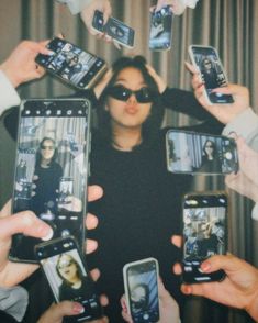 a group of people holding up cell phones in front of each other with their faces on them