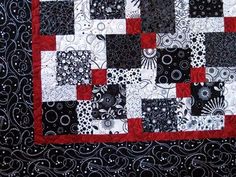 a black and white quilt with red accents