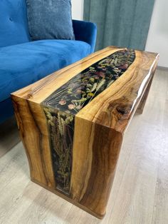 a wooden table sitting on top of a hard wood floor next to a blue couch