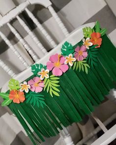 a close up of a chair with paper flowers on the back and fringes around it