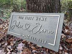 a sign that says our first home and an image of a tree in the background