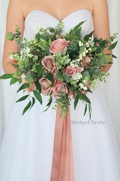 a bride holding a bouquet of flowers and greenery