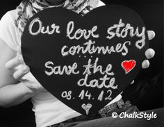 a woman holding up a black heart with writing on it that says our love story continues save the date