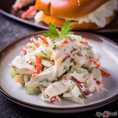 there is a salad on the plate and another sandwich in the background