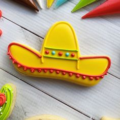 decorated cookies are arranged on a table with colorful icing and decorations around the cookie