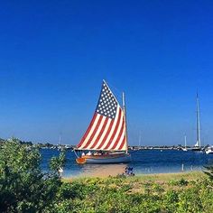 an american flag sailboat on the water