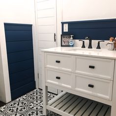 a bathroom with blue and white decor on the walls, flooring and countertop