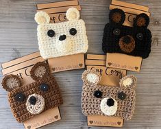 four crocheted bear purses are sitting on a table with tags attached to them