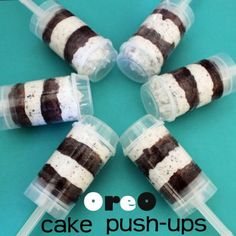 four brown and white striped cake pops in plastic containers on a blue background with text overlay that reads oreo cake push - ups