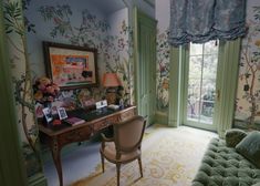 a living room filled with furniture and wallpaper covered in floral designs on the walls