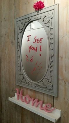 a mirror hanging on the wall above a shelf with a sign that says i see you