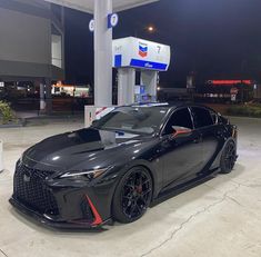 a black sports car parked at a gas station