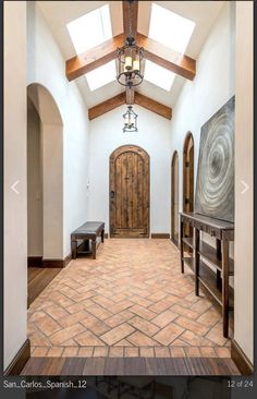 an entry way with a large wooden door and skylight in the center, surrounded by tile flooring