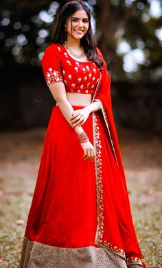 a woman in a red dress posing for the camera