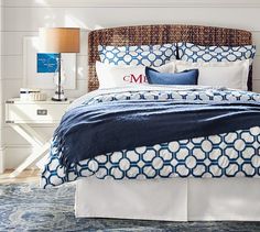 a bed with blue and white comforter on it's cover is featured in the pottery barn website