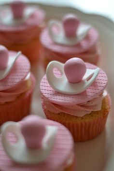 cupcakes with pink and white frosting on top are arranged in the shape of elephants