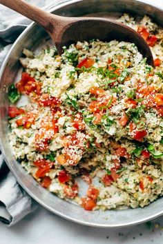 a pan filled with rice and vegetables on top of a table