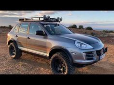 a silver suv parked on top of a dirt field